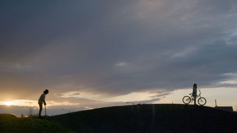 Silhouette de 2 enfants à un parc au coucher du soleil.